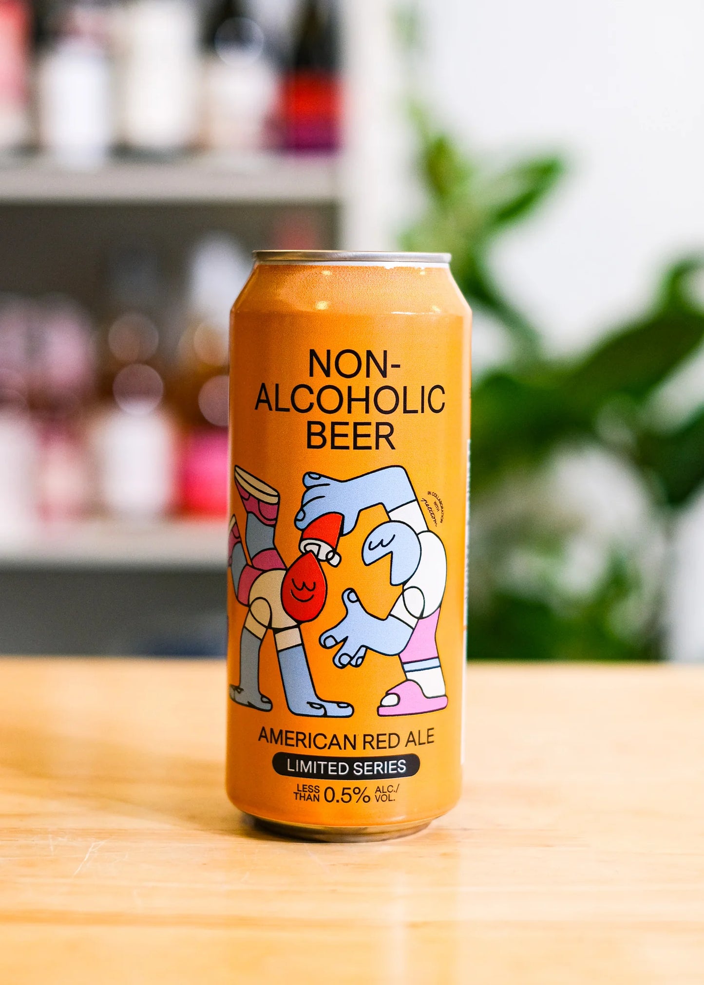 Can of non-alcoholic beer with cartoon characters on a wooden surface