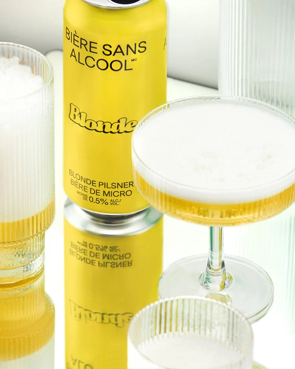 Yellow can of Biere Sans Alcool Blonde with a glass of beer on a white background