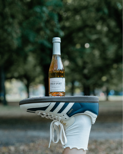 Bottle of cider on a shoe with a blurred outdoor background