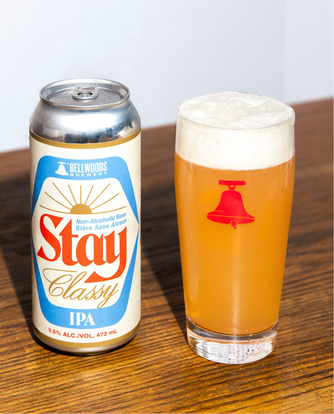 Can and glass of Stay Classy IPA on a wooden surface