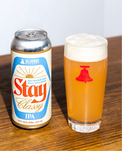 Can and glass of Stay Classy IPA on a wooden surface